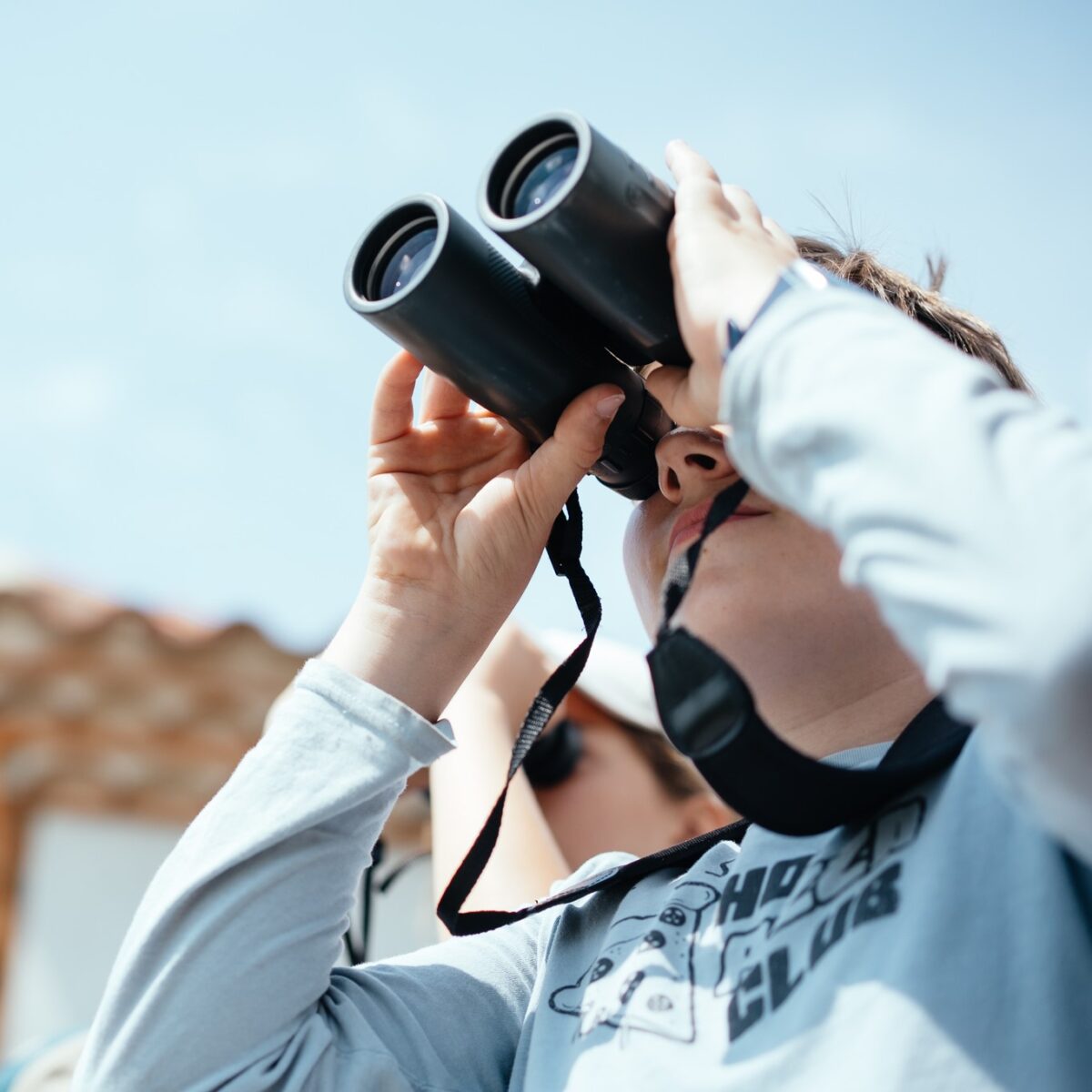 Un adolescent observe aux jumelles